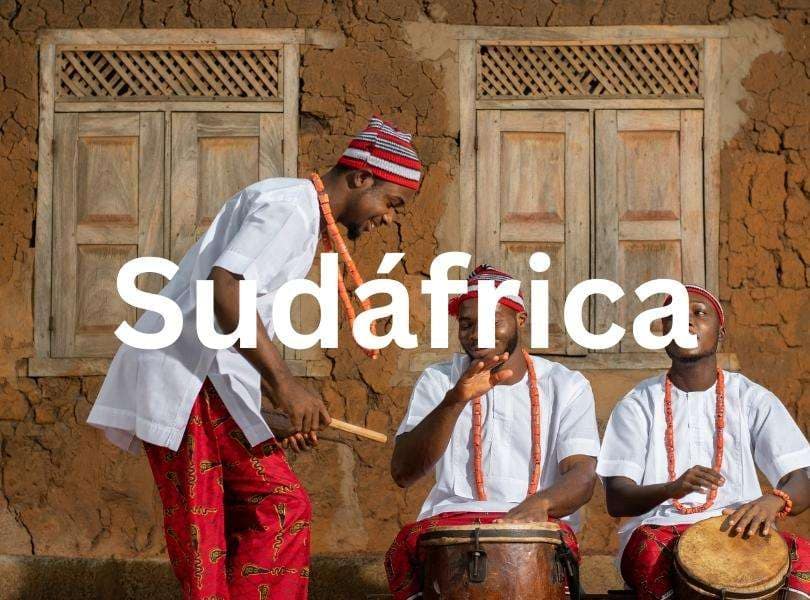 Año académico en Sudáfrica Tres hombres africanos en trajes tradicionales tocando tambores